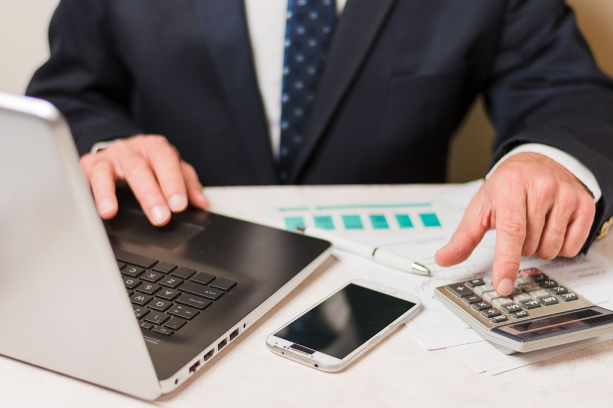 How to Deregister for GST Online A financial ledger and calculator on a desk, representing the final accounting steps and asset valuation required when you deregister for GST.