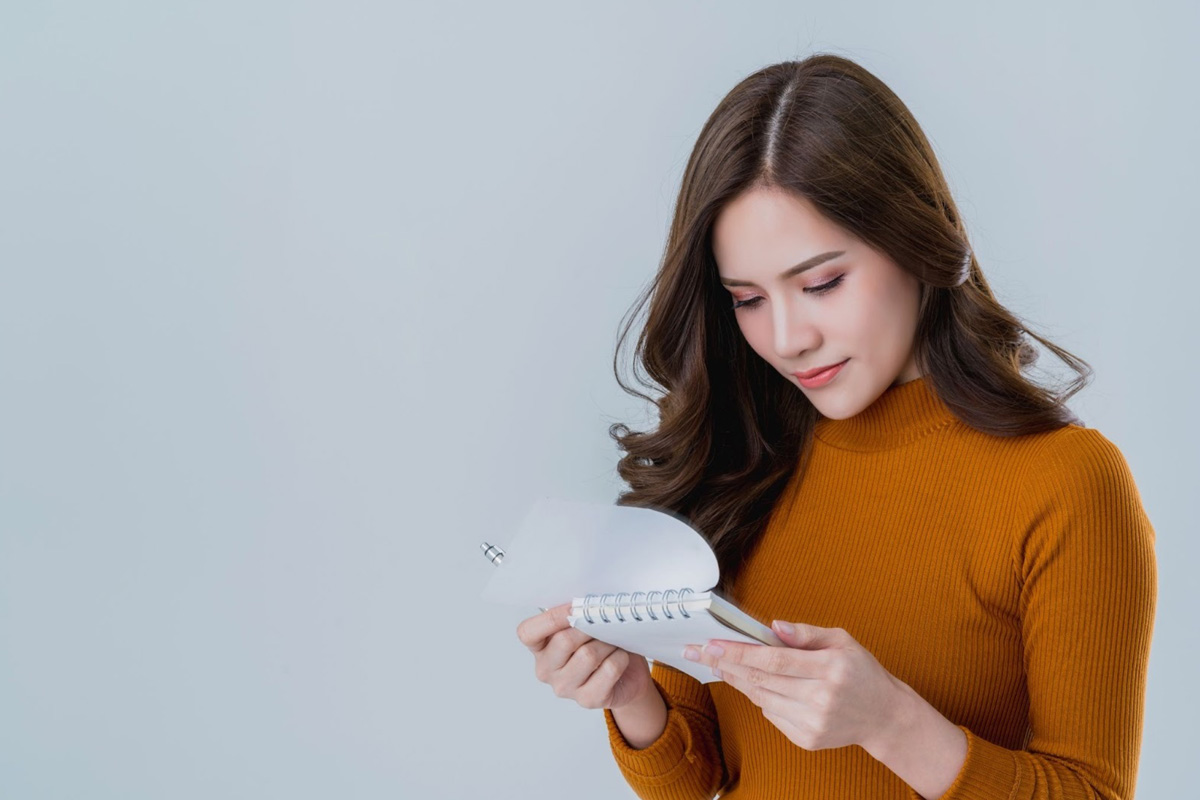 When to Deregister for GST A woman hovering over a calendar, focused on making the strategic decision to deregister for GST based on business turnover and compliance needs.