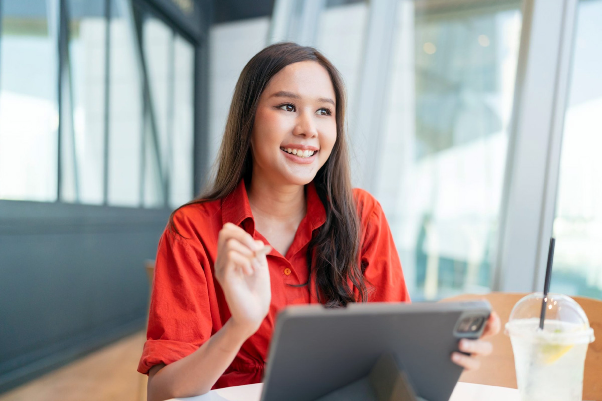 In-House Hiring vs Outsourcing: A Singapore Guide Singapore HR manager reviewing a large number of CVs on her laptop
