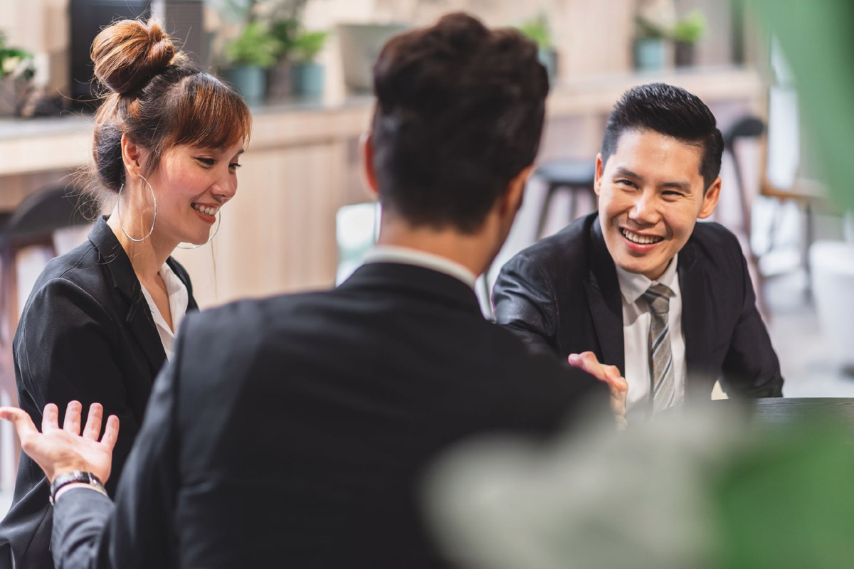 Business interruption insurance Singapore: A full guide Singapore SME team in a meeting, assessing operational risks and planning for business continuity.